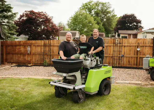 The Oriti family on Field of Dreams Lawn Care equipment — family-owned since 1997