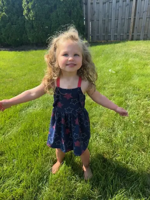 Young girl enjoying a mosquito-free lawn in Northeast Ohio after treatment by Field of Dreams Lawn Care